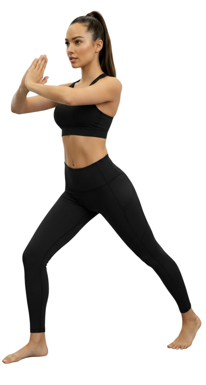 Woman in black athletic wear posing on a white background