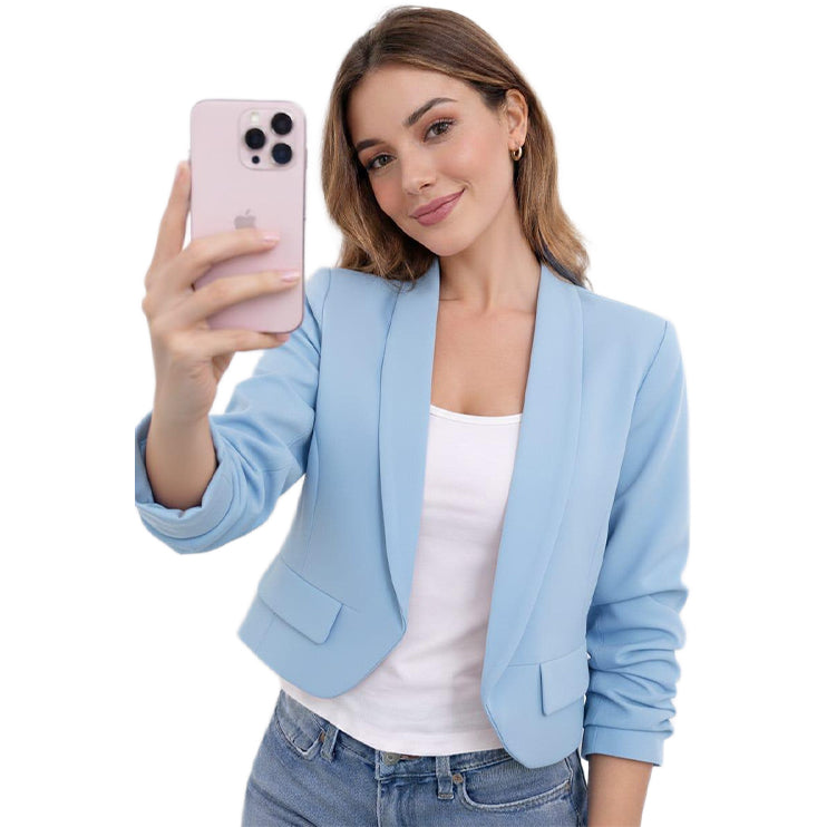 Woman in light blue blazer taking a selfie on a white background
