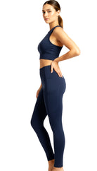 Woman wearing a navy blue athletic outfit on a white background