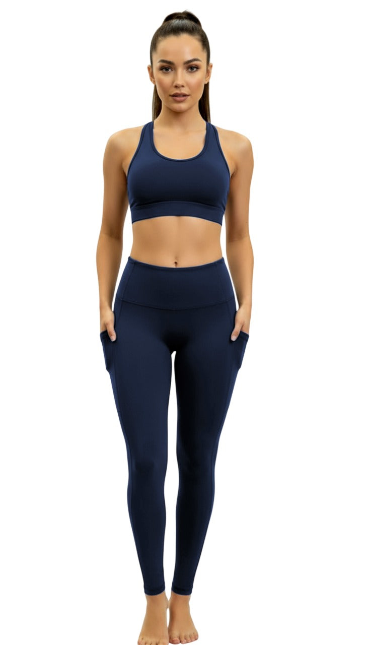 Woman wearing a navy blue sports bra and leggings set on a white background