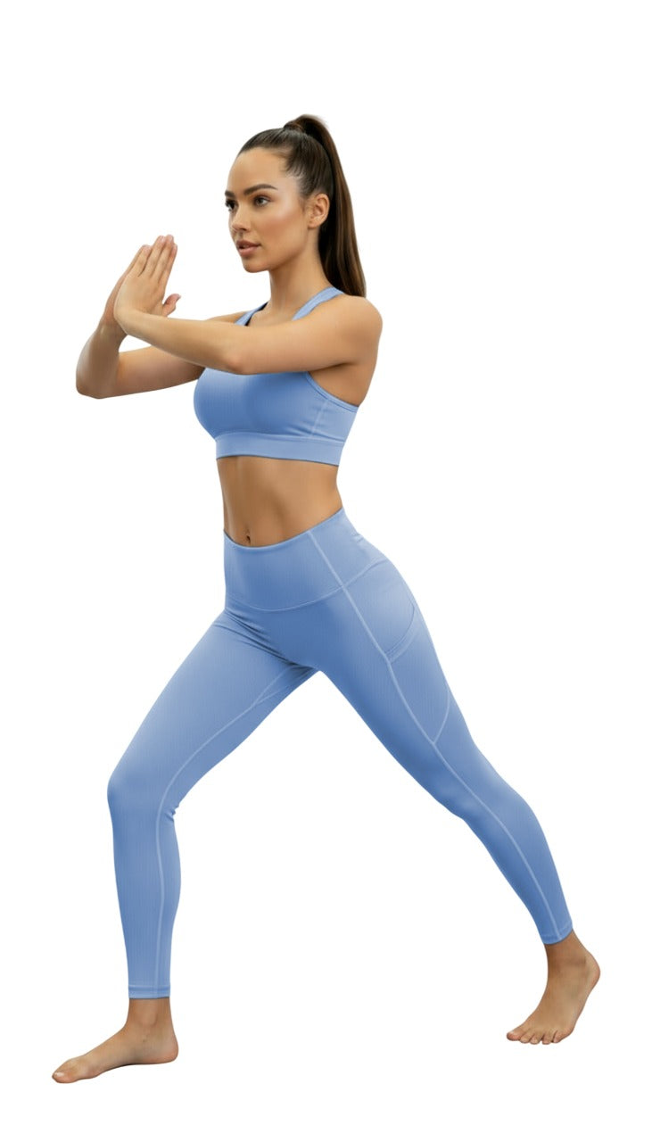 Woman in blue athletic wear posing on a white background