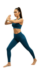 Woman in blue athletic wear posing against a white background