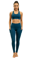 Woman wearing a teal sports bra and leggings set on a white background